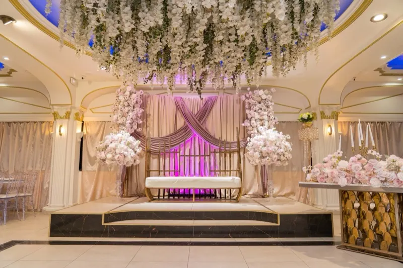 Décor floral rose et backdrop drapé pour l'espace des mariés